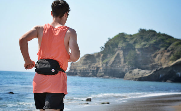A person running wearing the the Side Effect as a hip pack using the optional Gate Keeper Waist Strap.